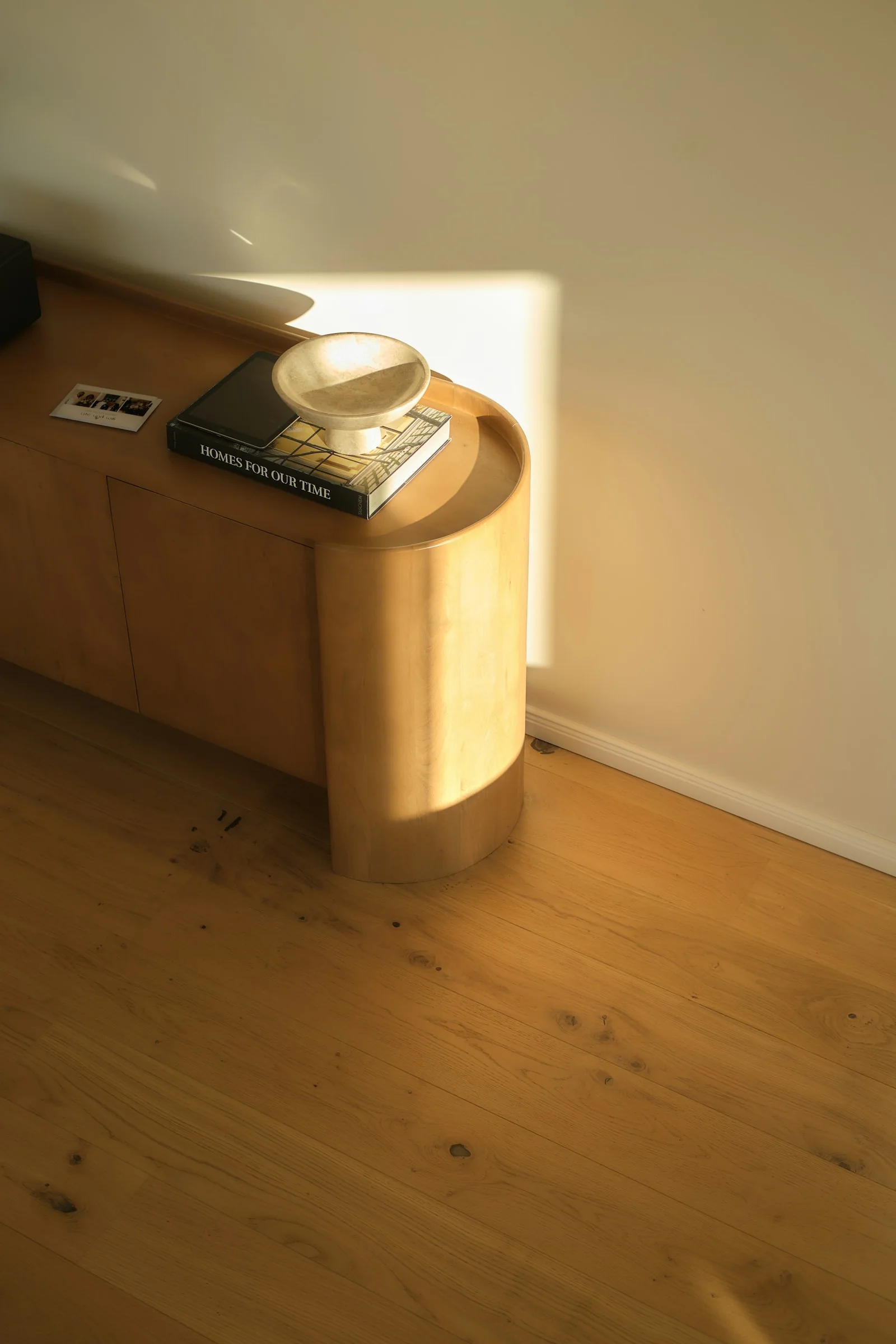 Warm sunlight across a wooden cabinet and floor